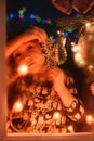 smiling sweet child girl standing by window at Christmas time. With colorful lights from Christmas tree on background Royalty Free Stock Photo
