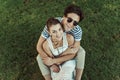 Smiling sweethearts hugging and looking at camera while sitting on grass Royalty Free Stock Photo