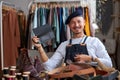 smiling talented craftsman holding leather handsmade thing in hands Royalty Free Stock Photo