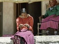 Smiling Tarahumara woman sitting outdoors and making pine-needle baskets