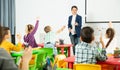 Smiling teacher examining pupils at lesson