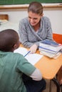 A smiling teacher explaining something to a pupil