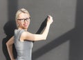 Smiling teacher with glasses standing in front of blackboard and holding book Royalty Free Stock Photo