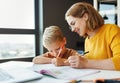 Cheerful mother doing homework with son at home Royalty Free Stock Photo