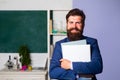 Smiling teacher professor standing in front of blackboard teaching student in classroom. Handsome school teacher in Royalty Free Stock Photo