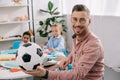 smiling teacher with soccer ball and multicultural classmates behind Royalty Free Stock Photo