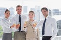 Smiling team of business people honoring a success with champagne