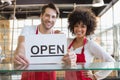 Smiling team posing behind the counter with open sign Royalty Free Stock Photo