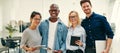 Smiling team of young businesspeople standing together in an office Royalty Free Stock Photo