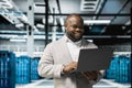 Smiling technician in data center workspace running system diagnostic tests Royalty Free Stock Photo