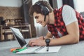 smiling teen boy with headphones playing game on laptop while lying on floor Royalty Free Stock Photo