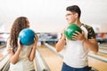 Teen Couple Holding Bowling Balls While Looking At Each Other Royalty Free Stock Photo