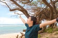 Smiling teen girl on beach by ocean arms stretched wide Royalty Free Stock Photo