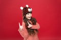 Smiling teen girl in cozy warm wear and winter hat pointing finger up, shopping winter sales Royalty Free Stock Photo