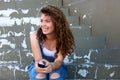 Smiling teen girl holding phone and sitting on steps Royalty Free Stock Photo