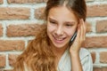 Smiling teen girl with long hair is talking on mobile phone Royalty Free Stock Photo