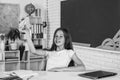 smiling teen girl play with paper plane in school classroom, childhood