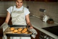 Smiling teen girl taking cookies out of the oven in the kitchen.Homemade cakes, cookies and gingerbread cookies. sweet breakfast Royalty Free Stock Photo