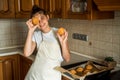 Smiling teen girl taking cookies out of the oven in the kitchen.Homemade cakes, cookies and gingerbread cookies. sweet breakfast Royalty Free Stock Photo