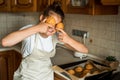 Smiling teen girl taking cookies out of the oven in the kitchen.Homemade cakes, cookies and gingerbread cookies. sweet Royalty Free Stock Photo