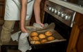 Smiling teen girl taking cookies out of the oven in the kitchen.Homemade cakes, cookies and gingerbread cookies. sweet breakfast Royalty Free Stock Photo