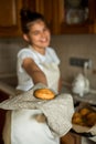 Smiling teen girl taking cookies out of the oven in the kitchen.Homemade cakes, cookies and gingerbread cookies. sweet breakfast. Royalty Free Stock Photo