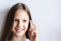 Smiling teen girl talking on a white push-button phone