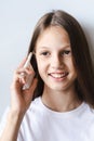 Smiling teen girl talking on a white push-button phone vertical view