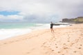 Smiling teen girl on tropical Hawaiian beach, waves crashing ashore