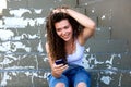 Smiling teen with hand in hair sitting with cellphone Royalty Free Stock Photo