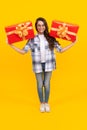 smiling teen kid holding box of present. teen kid with present isolated on yellow background.