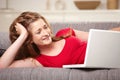 Smiling teen with laptop on sofa at home