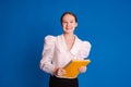 smiling teen student girl holding books wearing white shirt over blue studio background. Education in university college concept Royalty Free Stock Photo