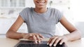 Smiling teenage african american girl pupil typing on keyboard, studying at laptop at home interior Royalty Free Stock Photo