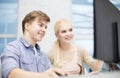 Smiling teenage boy and girl in computer class