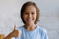 Smiling teenage boy showing thumbs up gesture.