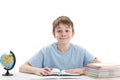 Smiling teenage boy sits at table with stack of notebooks doing homework. Education abroad concept. International education Royalty Free Stock Photo