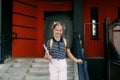 A smiling teenage girl with a backpack and a folder in her hands goes down the stairs, hurries to school. Back to school Royalty Free Stock Photo