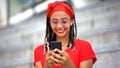 Smiling teenage girl chatting to boyfriend using smartphone, stylish lifestyle Royalty Free Stock Photo