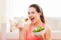 Smiling teenage girl with green salad at home Royalty Free Stock Photo