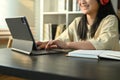 Smiling teenage girl in headphones studying online classes on digital tablet at home. Online learning concept Royalty Free Stock Photo