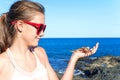 Smiling teenage girl holding an atlantic crab on ocean coast