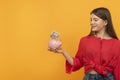 Smiling teenage girl holds piggy bank with dollars. Concepts of saving money and investments. Financial planning, savings Royalty Free Stock Photo