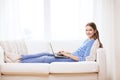 Smiling teenage girl with laptop computer at home Royalty Free Stock Photo