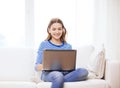 Smiling teenage girl with laptop computer at home Royalty Free Stock Photo