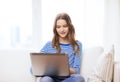 Smiling teenage girl with laptop computer at home Royalty Free Stock Photo