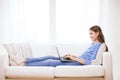 Smiling teenage girl with laptop computer at home Royalty Free Stock Photo