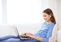 Smiling teenage girl with laptop computer at home Royalty Free Stock Photo