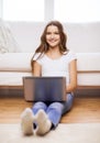 Smiling teenage girl with laptop computer at home Royalty Free Stock Photo