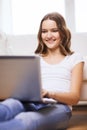 Smiling teenage girl with laptop computer at home Royalty Free Stock Photo